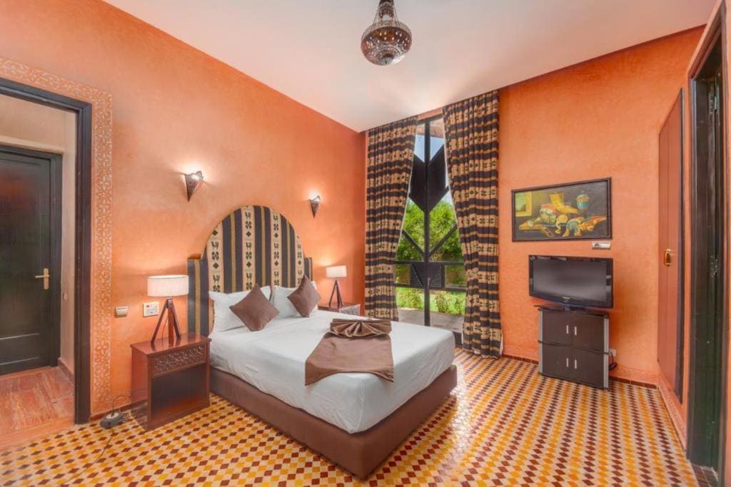 Stylish Moroccan bedroom with large king-size bed and pink accents