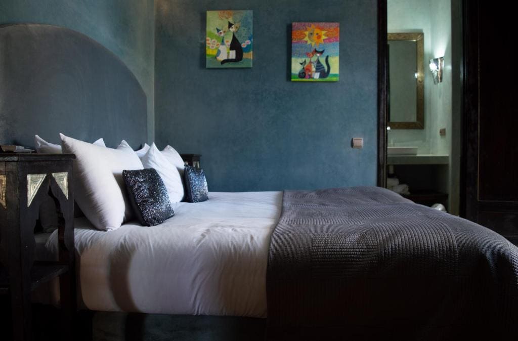 Stylish Moroccan bedroom with large king-size bed and pink accents