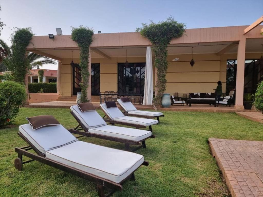 Luxury villa pool area surrounded by palm trees in Marrakech